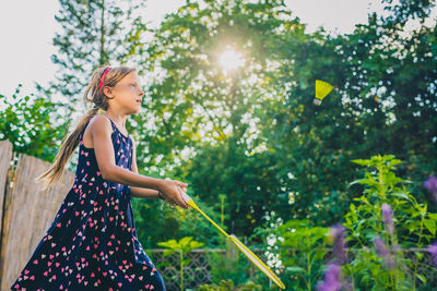 Girl playing against tree