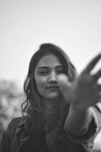 Portrait of woman standing against black background