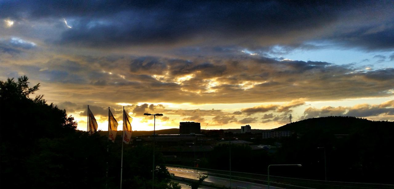 sunset, sky, building exterior, cloud - sky, silhouette, architecture, built structure, orange color, tree, cloudy, beauty in nature, dramatic sky, scenics, nature, house, dusk, landscape, cloud, city, weather