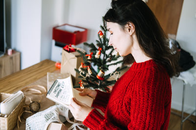 Young woman using mobile phone while sitting on table