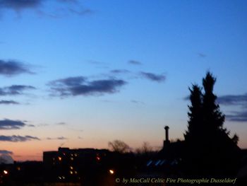 Silhouette cityscape against sky at dusk