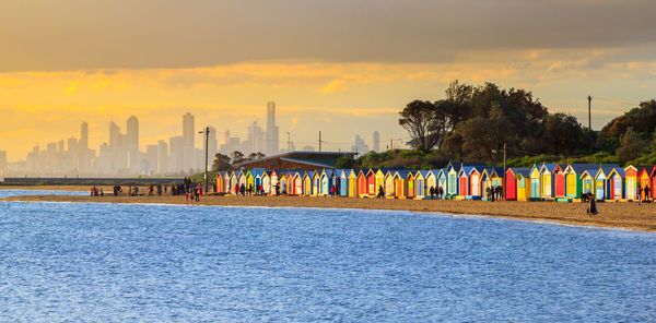 Scenic view of sea against buildings during sunset