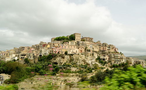 Buildings in city against cloudy sky