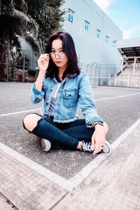 Portrait of beautiful young woman sitting in city