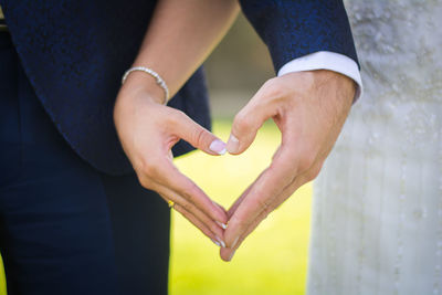 Midsection of couple holding heart shape