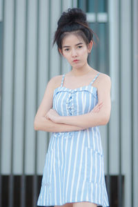 Portrait of woman standing against wall