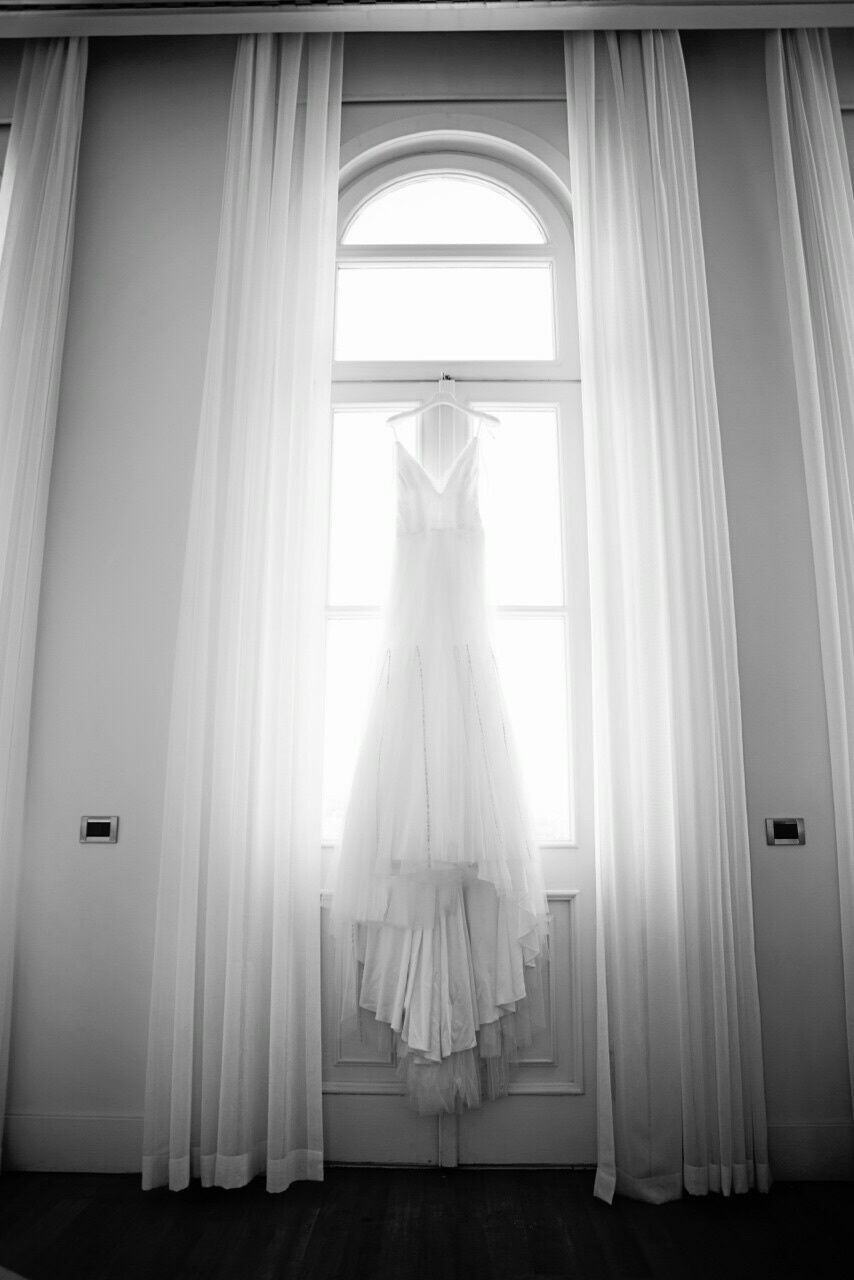 indoors, window, curtain, home interior, one person, door, architecture, glass - material, built structure, sunlight, doorway, open, looking through window, white color, transparent, house, day, arch, domestic room, corridor