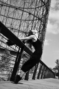 Low angle view of young woman against built structure