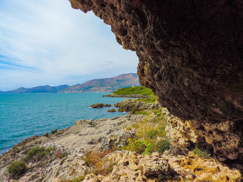 Rock formations by sea against sky