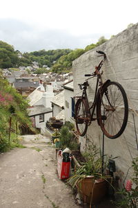 Bicycle by building against sky