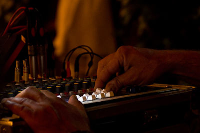 Cropped hands of man adjusting sound mixer