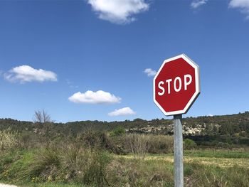 Information sign on road against sky