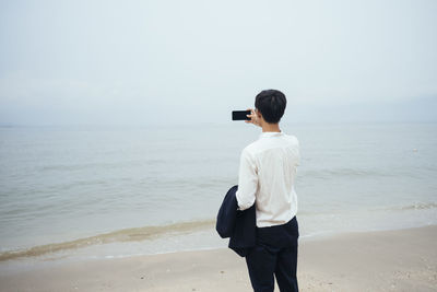 Rear view of man standing on beach