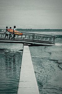 Man standing on pier by sea