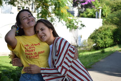 Happy friends smiling while standing outdoors