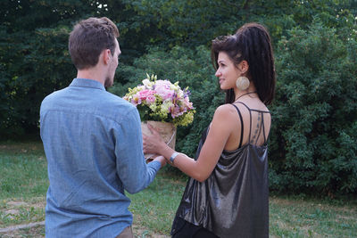 Young couple standing by flowering plants