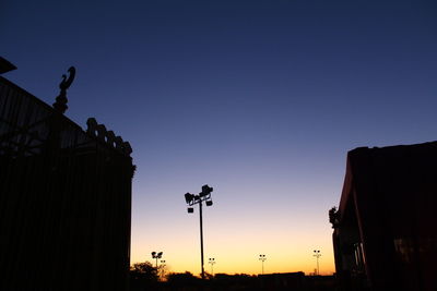 Low angle view of silhouette buildings against clear sky