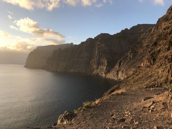 Scenic view of sea and mountains against sky