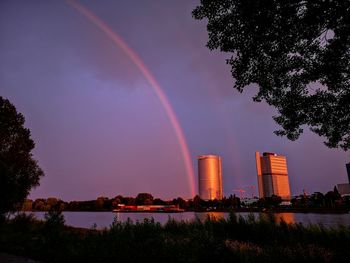 Low angle view of rainbow over city against sky