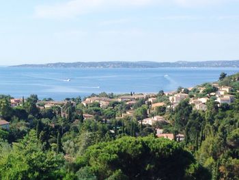 Scenic view of sea and cityscape against sky