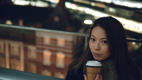 Portrait of young woman drinking glass