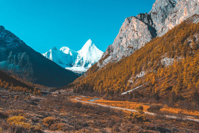 Scenic view of snowcapped mountains against clear blue sky