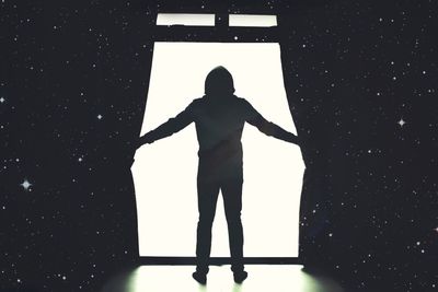 Rear view of silhouette man standing against the sky