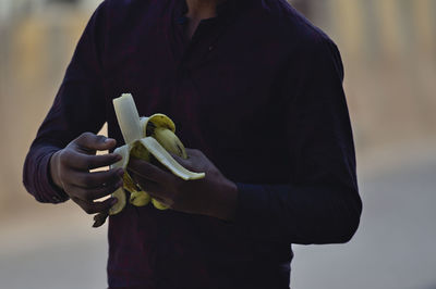 Midsection of man holding umbrella