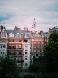 Buildings in city against cloudy sky