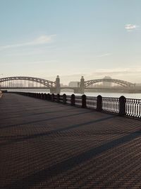 Bridge over river in city against sky during sunset