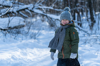 Portrait of smiling boy on snow covered land