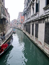 Boats in canal amidst buildings in city