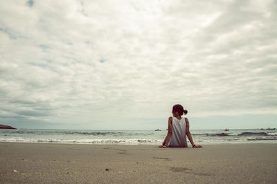 Rear view of woman looking at sea against sky