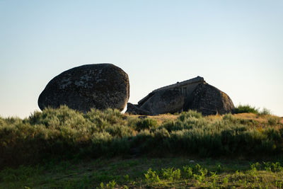 Rocks on field against clear sky