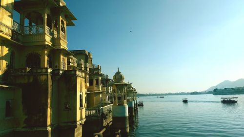 Boats in sea against buildings