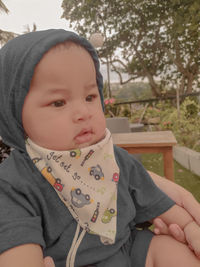 Portrait of cute baby girl sitting outdoors