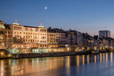 Illuminated buildings against sky at dusk