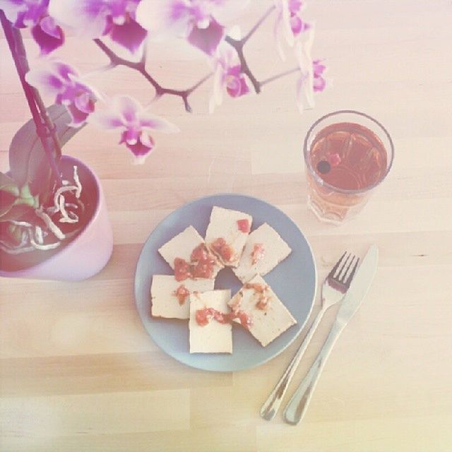 table, indoors, freshness, food and drink, still life, flower, drink, high angle view, refreshment, vase, drinking glass, spoon, plate, glass - material, food, close-up, no people, fork, wood - material, coffee cup