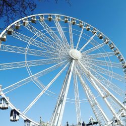 Low angle view of ferris wheel against blue sky