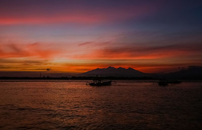 Scenic view of sea against dramatic sky during sunset