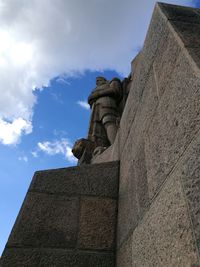 Low angle view of statue against building against sky