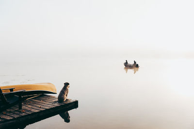 People on boat in sea against sky