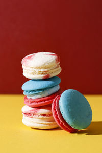 Colorful macaroon, stacked on yellow and red background. balanced food concept bold color for bakery