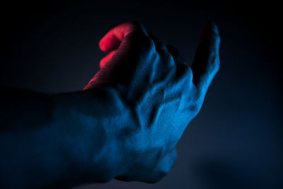 Male hand illuminated with blue light