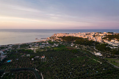 High angle view of townscape by sea against sky