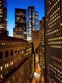 Illuminated buildings in city against sky at night