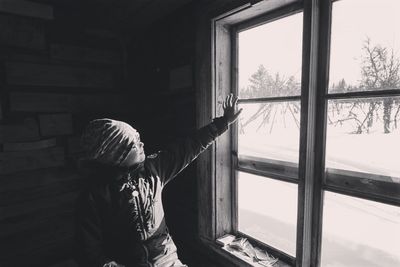 Rear view of woman walking through window