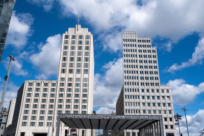 Low angle view of buildings against cloudy sky