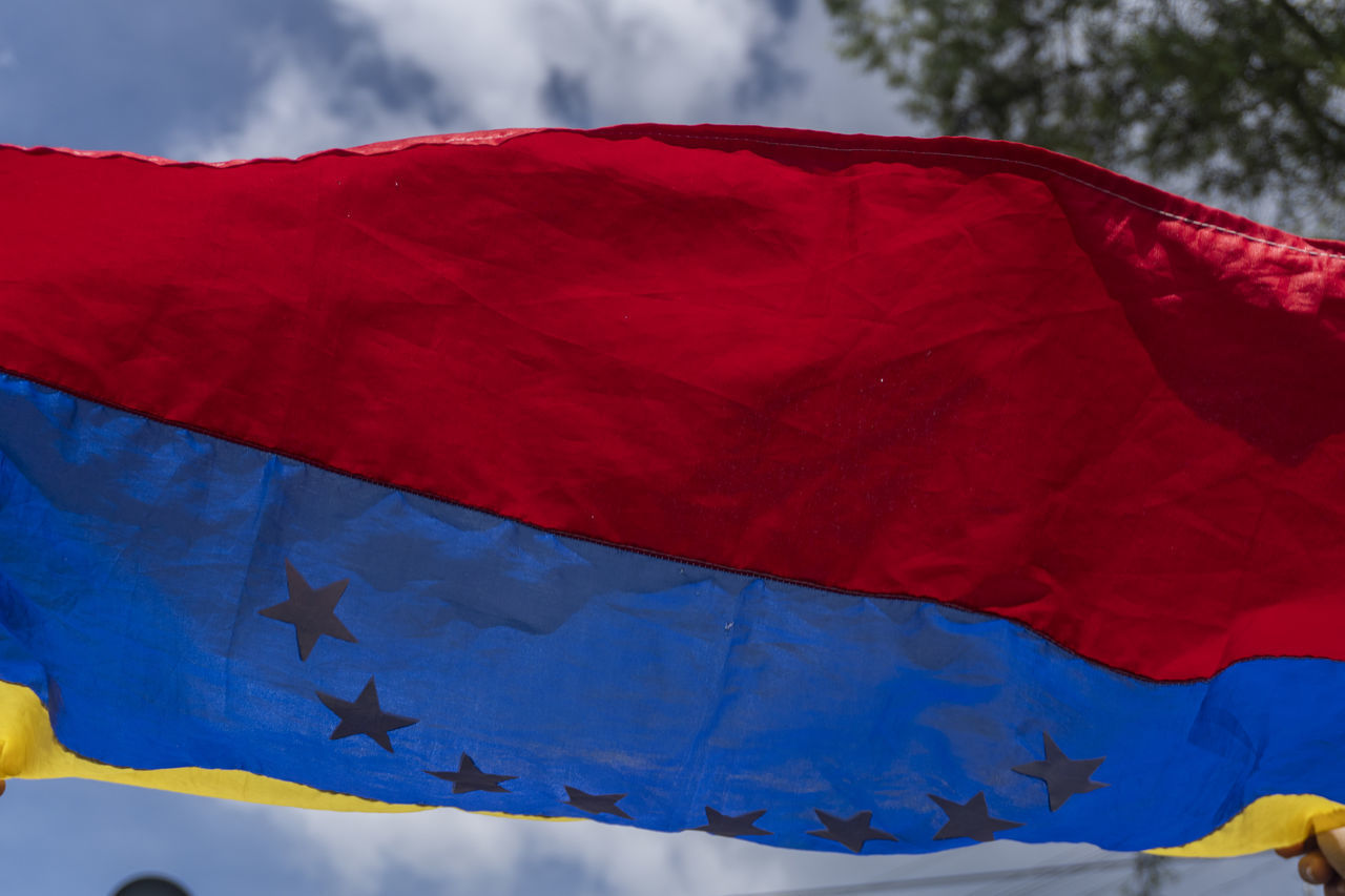 LOW ANGLE VIEW OF FLAGS HANGING AGAINST SKY