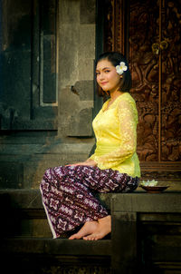 Beautiful young woman sitting outdoors